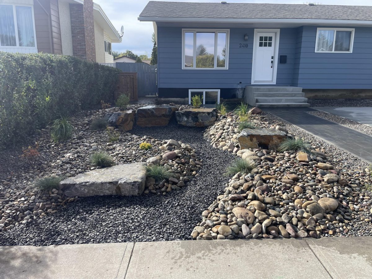 Dry Riverbed 003 custom front yard landscaping, rock bed with small plants and a fake rock river