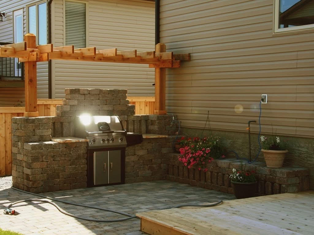 custom paver patio with barbecue built into paver wall